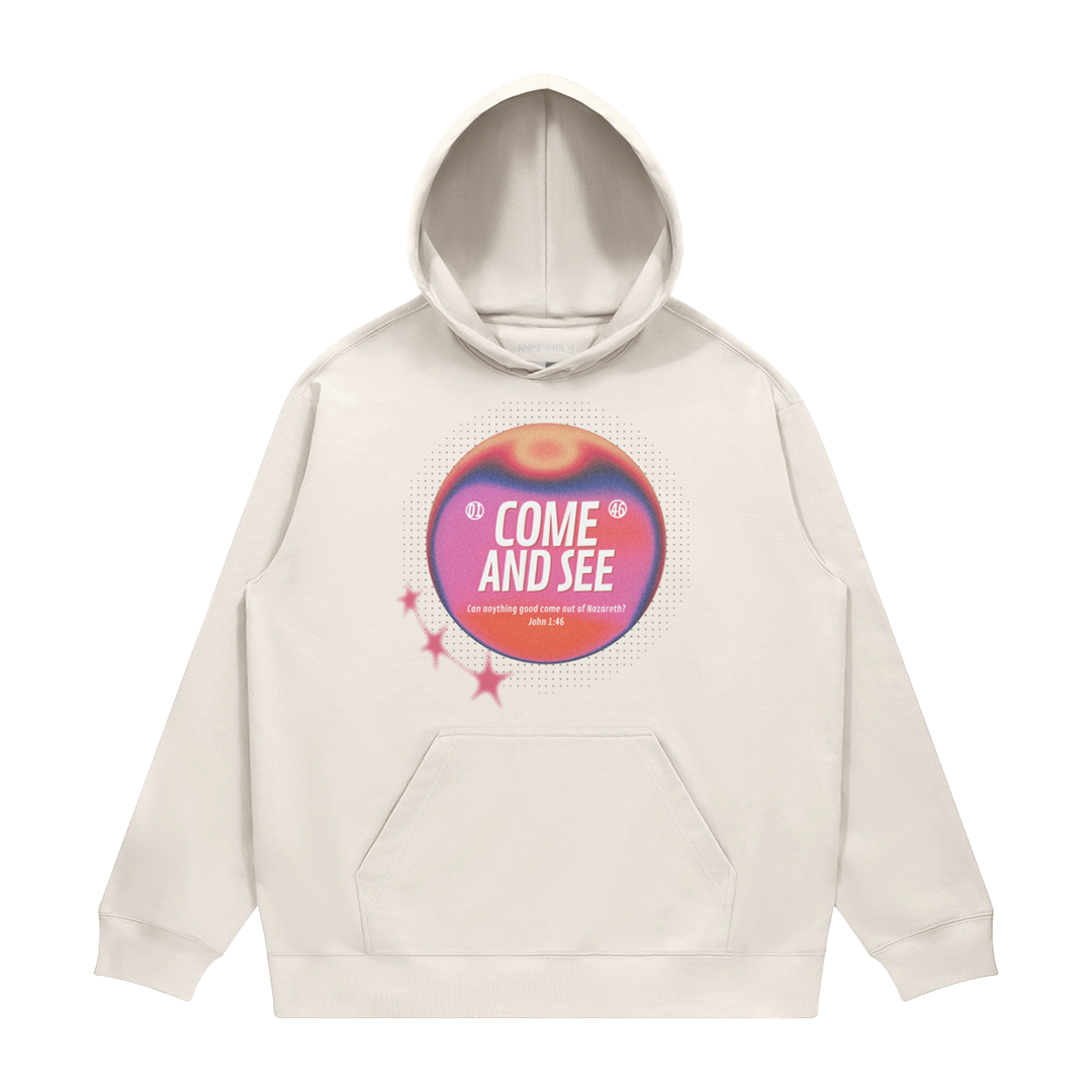 hype4holy come and see heavyweight hoodie cream front Beige hoodie with a colorful graphic and text on a white background