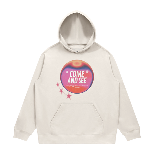 hype4holy come and see heavyweight hoodie cream front Beige hoodie with a colorful graphic and text on a white background