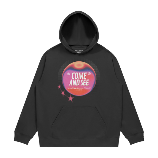 hype4holy come and see heavyweight hoodie black front Black hoodie with a colorful graphic design on a white background