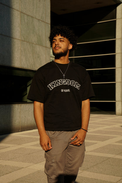 hype4holy premium christian streetwear | Man wearing a black t-shirt with 'Kingdom of Heaven' text, standing outdoors.